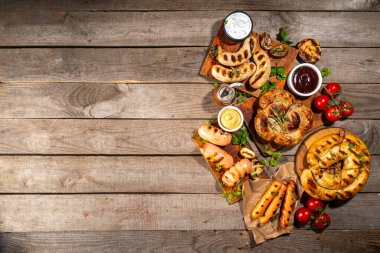 Bavyera sosisi, yuvarlak, gumberland, ketçaplı sucuk, hardal barbekü sosu. Çeşitli bbq ızgara sosisler ahşap arka planda yatıyordu. Sokak festivali ızgara yemek menüsü. 