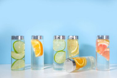 Şişe içinde çeşitli soğuk içecekler, yaz aşılamalı su şişeleri, limonata sağlıklı kokteyller limon, portakal, greyfurt, ıhlamur, parlak arka plan kopyalama alanı