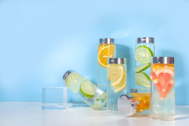 Şişe içinde çeşitli soğuk içecekler, yaz aşılamalı su şişeleri, limonata sağlıklı kokteyller limon, portakal, greyfurt, ıhlamur, parlak arka plan kopyalama alanı