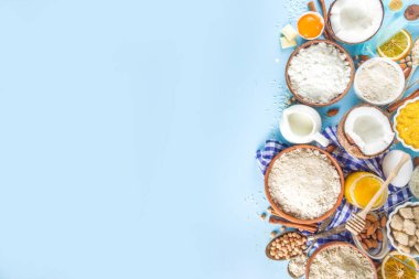 Pişirme arka plan çerçeve arka planı. Çeşitli glütensiz un ve malzemeler, tatlı ve ekmek fırını için, renkli mavi mutfak masasında çatal bıçak, yumurta, şeker, tarçın