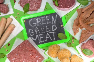 Yeşil arka planda laboratuvar ürünü veya bitki bazlı kırmızı et biftekleri