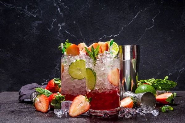 Strawberry citrus summer cooling drink, iced berry mojito lemonade with strawberries, mint and lime