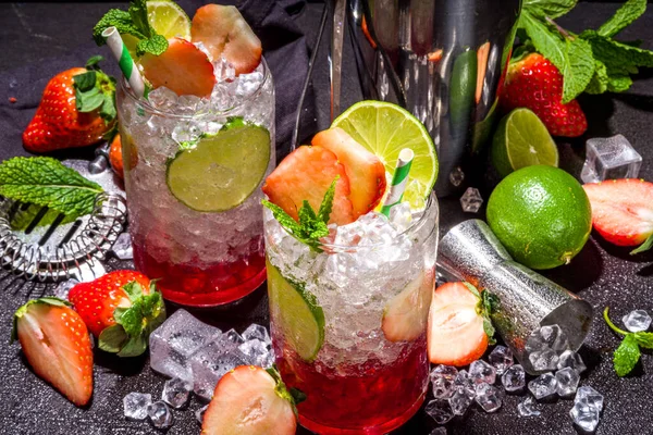 Strawberry citrus summer cooling drink, iced berry mojito lemonade with strawberries, mint and lime