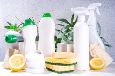 Çevre dostu organik temizlik konsepti. Çevre dostu temizlik aletleri - eko fırçalar, aletler süngerler, doğal temizlik ürünleri, soda, sabun, limon, sirke, beyaz arka planda yeşil yapraklı şişeler