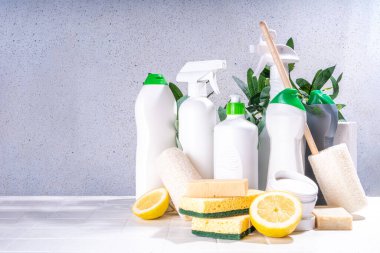 Çevre dostu organik temizlik konsepti. Çevre dostu temizlik aletleri - eko fırçalar, aletler süngerler, doğal temizlik ürünleri, soda, sabun, limon, sirke, beyaz arka planda yeşil yapraklı şişeler