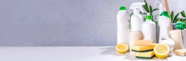 Çevre dostu organik temizlik konsepti. Çevre dostu temizlik aletleri - eko fırçalar, aletler süngerler, doğal temizlik ürünleri, soda, sabun, limon, sirke, beyaz arka planda yeşil yapraklı şişeler