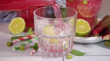 Ev yapımı pembe rengarenk limonata. Soğuk yaz içkileri çiğ ravent, limon dilimleri ve nane.