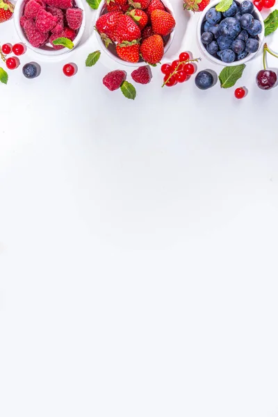 Summer vitamin food concept, set of various berries blueberry strawberry currant,  flat lay on white background top view copy space