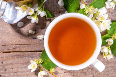 Bitkisel yasemin çiçeği çayı. Cam çaydanlıkta yasemin yeşili çay ve taze yasemin çiçekli beyaz çay fincanı.