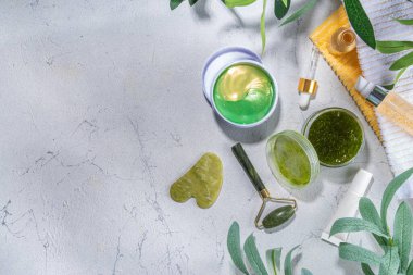 Doğa Yaşlanma Karşıtı Kozmetik, Terapi Masajı. Asya güzellik bakımı. Yeşim silindir, gua sha masaj aleti çeşitli organik serumlar, jel, bitkisel özler, spa havluları. Beyaz mermer arka planda düz alan