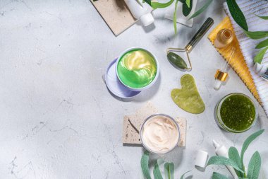 Doğa Yaşlanma Karşıtı Kozmetik, Terapi Masajı. Asya güzellik bakımı. Yeşim silindir, gua sha masaj aleti çeşitli organik serumlar, jel, bitkisel özler, spa havluları. Beyaz mermer arka planda düz alan