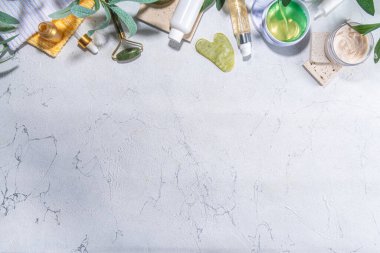 Doğa Yaşlanma Karşıtı Kozmetik, Terapi Masajı. Asya güzellik bakımı. Yeşim silindir, gua sha masaj aleti çeşitli organik serumlar, jel, bitkisel özler, spa havluları. Beyaz mermer arka planda düz alan