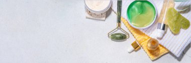 Doğa Yaşlanma Karşıtı Kozmetik, Terapi Masajı. Asya güzellik bakımı. Yeşim silindir, gua sha masaj aleti çeşitli organik serumlar, jel, bitkisel özler, spa havluları. Beyaz mermer arka planda düz alan