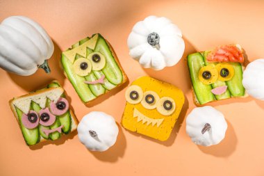 Çeşitli komik canavar Cadılar Bayramı sandviçleri. Çeşitli yaratıcı kahvaltı atıştırmalıklarını peynirli tostları, Cadılar Bayramı çocuklarının parti yemeklerini, üst manzarayı ayarlayın. 