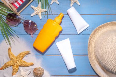 Sunscreen suncare background. Mockup background with vacation accessory, suntan lotion bottle, cosmetic cream, with seashells, straw woman's hat with sun glasses, top view copy space