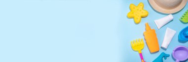 Bebek güneş kremi konsepti. Çocuklarla birlikte güneş kremi şişeleri tatil aksesuarları, kum kalıpları, panama şapkaları, açık mavi arka plan fotokopi alanı.