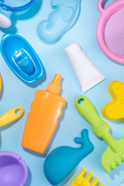 Bebek güneş kremi konsepti. Çocuklarla birlikte güneş kremi şişeleri tatil aksesuarları, kum kalıpları, panama şapkaları, açık mavi arka plan fotokopi alanı.