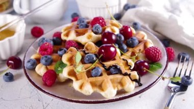 Böğürtlenli tatlı waffle. Ahududu, yabanmersini, çilek, bal ve çikolata soslu ev yapımı Belçika waffle 'ı.