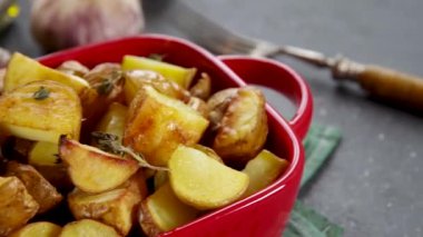 Slices of fried or baked potato wedges with herbs and spices in frying pan