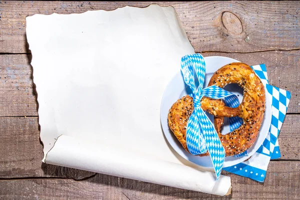 Oktoberfest holiday background, menu mockup. Bavaria flag oktoberfest festival napkin, pretzel, beer bottle and mug on old rustic wooden background, copy space top view