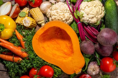 Sonbahar sebzeleri pişirme arka planı. Organik sonbahar hasat çiftliği sebzeleri, mantarlar. Ahşap mutfak arka planında akşam yemeği hazırlamak için çeşitli vejetaryen malzemeler.