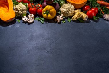Sonbahar sebzeleri pişirme arka planı. Organik sonbahar hasat çiftliği sebzeleri, mantarlar. Siyah mutfak arka planında yemek pişirmek için çeşitli vejetaryen malzemeler, üst görünüm kopyalama alanı