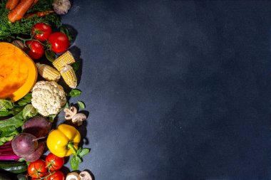 Sonbahar sebzeleri pişirme arka planı. Organik sonbahar hasat çiftliği sebzeleri, mantarlar. Siyah mutfak arka planında yemek pişirmek için çeşitli vejetaryen malzemeler, üst görünüm kopyalama alanı