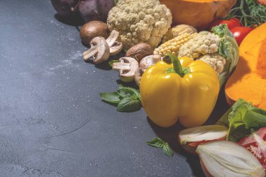 Sonbahar sebzeleri pişirme arka planı. Organik sonbahar hasat çiftliği sebzeleri, mantarlar. Siyah mutfak arka planında yemek pişirmek için çeşitli vejetaryen malzemeler, üst görünüm kopyalama alanı