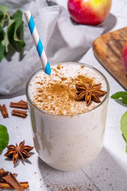 Apple pie smoothie with yogurt, apple slices, oatmeal granola flakes, cinnamon, spices and walnuts. Healthy uatumn breakfast or snack, with fresh raw apples and spices copy space