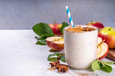 Apple pie smoothie with yogurt, apple slices, oatmeal granola flakes, cinnamon, spices and walnuts. Healthy uatumn breakfast or snack, with fresh raw apples and spices copy space