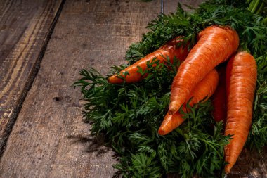Kırsal ahşap arka planda yeşil yapraklı taze organik havuç kopyalama alanı