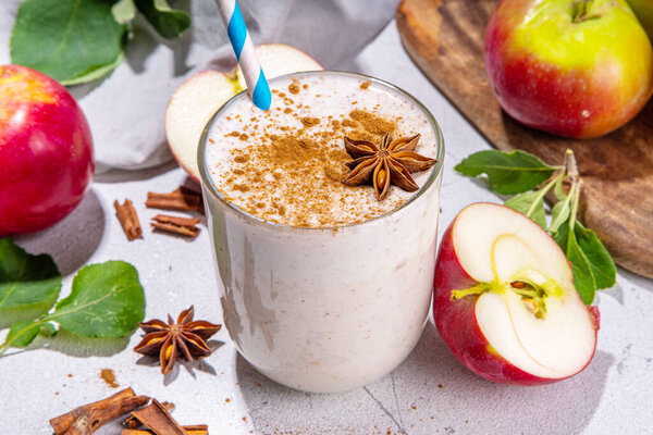 Apple pie smoothie with yogurt, apple slices, oatmeal granola flakes, cinnamon, spices and walnuts. Healthy uatumn breakfast or snack, with fresh raw apples and spices copy space