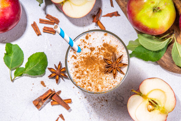 Apple pie smoothie with yogurt, apple slices, oatmeal granola flakes, cinnamon, spices and walnuts. Healthy uatumn breakfast or snack, with fresh raw apples and spices copy space