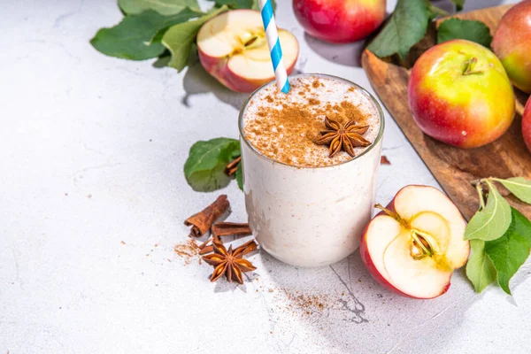 Apple pie smoothie with yogurt, apple slices, oatmeal granola flakes, cinnamon, spices and walnuts. Healthy uatumn breakfast or snack, with fresh raw apples and spices copy space