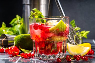 Kırmızı üzümlü limonata ya da mojito kokteyli. Frenk üzümü, limon, miint ve buz ile buzlu taze yaz kokteyli. Koyu renkli arkaplan kopyalama alanı