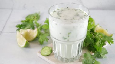 Taze Asya yoğurdu kefir içer, kırık otlarla bardakta ayran içer. Ayran, yaz için sebzeli, limonlu, salatalıklı sağlıklı bir kokteyl. Probiyotik, postbiyotik mayalanmış süt içeceği.