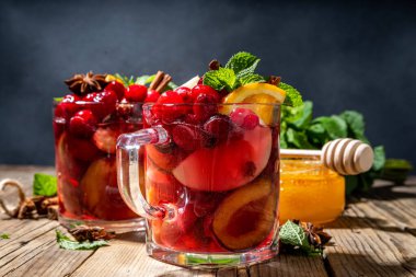 Noel şarabı, aromatik baharatlar, narenciye ve böğürtlen. Sıcak sonbahar kış meyveli içecek kırmızı şaraplı, eski kırsal ahşap arka planda fotokopi alanı 