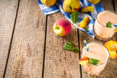 Yaz kahvaltısı içeceği, taze şeftalili smoothie, şeftalili yoğurt nektarin dilimleri, kırsal ahşap arka plan fotokopi alanı.