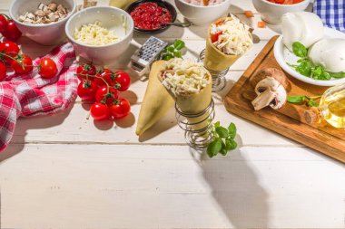 Cooking trendy Cone pizza background, modern pizza recipe, with tomatoes, basil, mozzarella cheese, baked pizza cones dough, ham and mushrooms