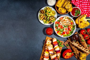 Izgara yaz bbq tabakları. Barda piknik pikniği çeşitli ızgara yiyeceklerle - şiş kebap şiş şiş, ızgara mısır, kızarmış tavuk salata, biftek, sosis, sebze