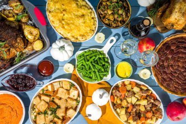 Geleneksel Şükran Günü yemeğiyle birlikte Şükran Günü sofrası. Tavuk, patates püresi, taze fasulye, cevizli turta, fırında domuz eti, peynirli makarna, dolma, modern sert, güneşli, yassı bir ev.