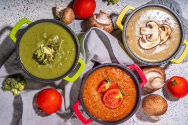 Autumn vegetable cream soups set. Three portion pots with various vegan hot vegetable cream soups tomato, mushrooms, broccoli on rustic wooden table copy space
