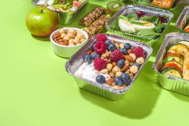 Sağlıklı yemek menüsü, kurye yemek teslimatı beslenme çantası. Biftek eti, tavuk fileto, balık ve sebzeler paketlerde. Günlük yemek diyet planı teslimatı, paket servisi, online sipariş konsepti.