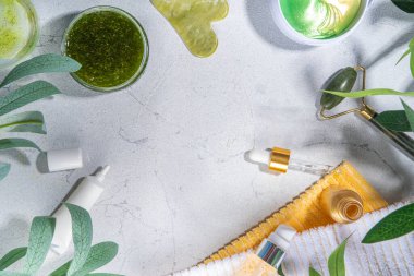 Doğa Yaşlanma Karşıtı Kozmetik, Terapi Masajı. Asya güzellik bakımı. Yeşim silindir, gua sha masaj aleti çeşitli organik serumlar, jel, bitkisel özler, spa havluları. Beyaz mermer arka planda düz alan
