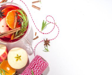 Ev yapımı sıcak şarap kokteyli. Klasik kış baharatlı sıcak sıcak sıcak şaraplı çeşitli cam bardaklar, beyaz arka plandaki malzemeler üst görünüm kopya alanı