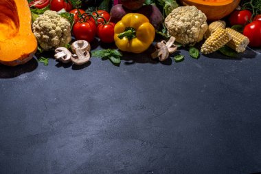 Sonbahar sebzeleri pişirme arka planı. Organik sonbahar hasat çiftliği sebzeleri, mantarlar. Siyah mutfak arka planında yemek pişirmek için çeşitli vejetaryen malzemeler, üst görünüm kopyalama alanı