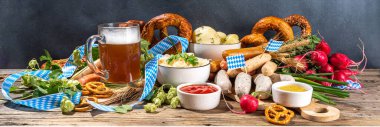 Oktoberfest holiday greeting card, menu, invitation background, Traditional Oktoberfest festival food, bavarian sausages, pretzels, potato, sauerkraut, beer mug on wooden background, banner format