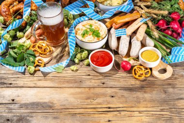 Oktoberfest holiday greeting card, menu, invitation background, Traditional Oktoberfest festival food, bavarian sausages, pretzels, potato, sauerkraut, beer mug on wooden background, copy space above