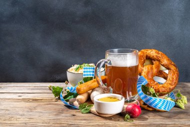 Oktoberfest holiday greeting card, menu, invitation background, Traditional Oktoberfest festival food, bavarian sausages, pretzels, potato, sauerkraut, beer mug on wooden background, copy space above