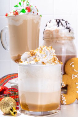 Autumn winter coffee latte set, Autumn winter coffee drink assortment with various topping - gingerbread caramel, mocha chocolate, candy cane peppermint latte in different cups, on white background